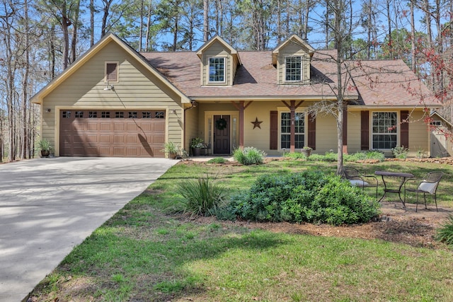 cape cod-style house with driveway, a shingled roof, and an attached garage