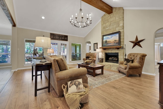 living room with arched walkways, a fireplace, light wood-style floors, beam ceiling, and crown molding