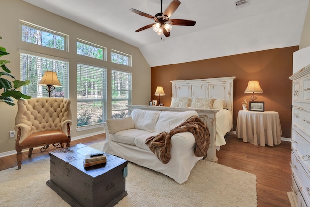 bedroom with visible vents, vaulted ceiling, baseboards, and wood finished floors