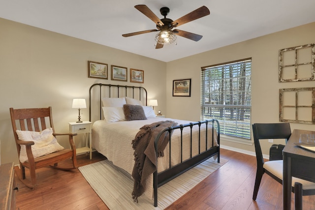 bedroom with a ceiling fan, hardwood / wood-style flooring, and baseboards