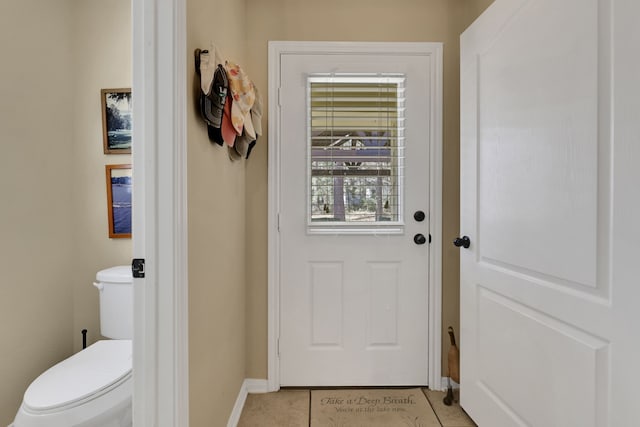 entryway with baseboards and light tile patterned flooring