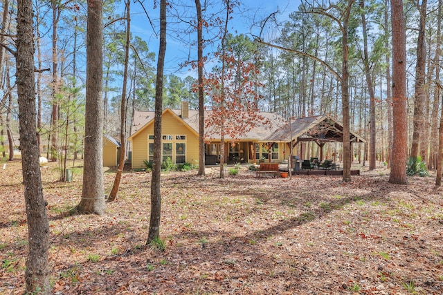 back of property featuring a gazebo and a chimney