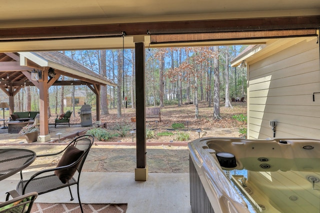 view of patio / terrace featuring a hot tub and a gazebo