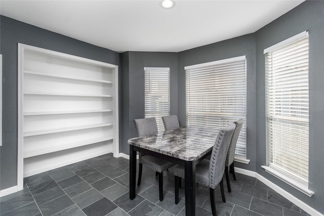 dining area featuring built in shelves and baseboards