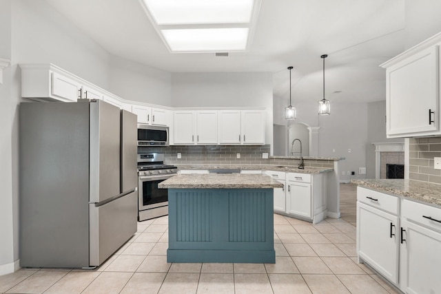 kitchen featuring a peninsula, light tile patterned floors, white cabinetry, and stainless steel appliances