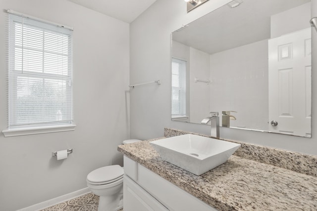 bathroom with toilet, baseboards, and vanity