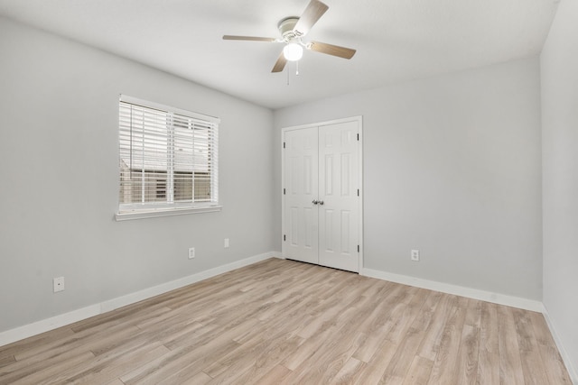 spare room featuring wood finished floors, a ceiling fan, and baseboards