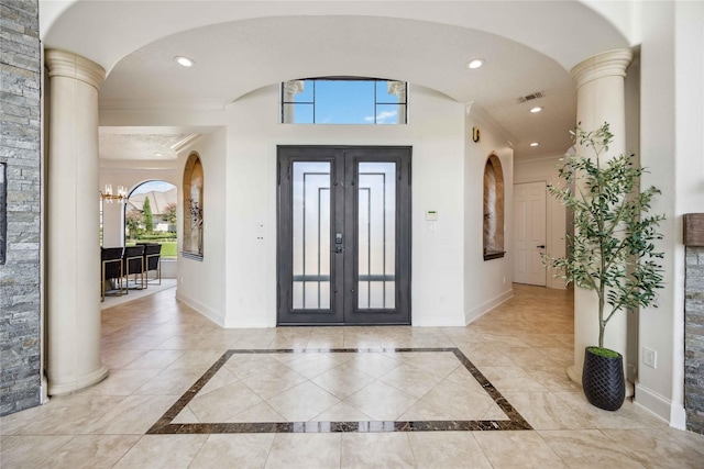 entrance foyer with french doors, baseboards, visible vents, a chandelier, and ornamental molding