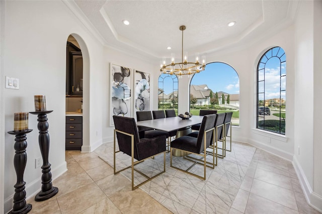 dining area with crown molding, a chandelier, a tray ceiling, and recessed lighting