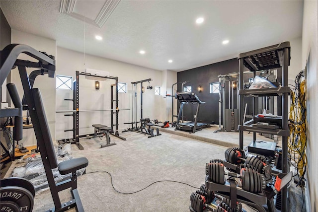 exercise room featuring attic access, a textured ceiling, carpet flooring, and recessed lighting