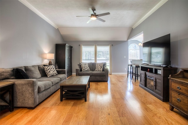 living area featuring vaulted ceiling, light wood-style flooring, and crown molding