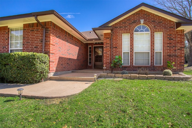 view of front of property featuring a front lawn and brick siding