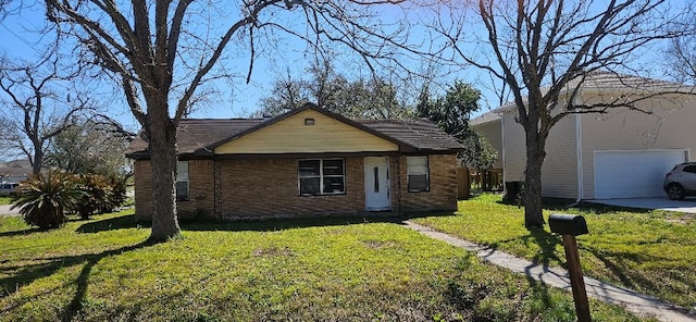 view of front of property featuring brick siding, a garage, and a front lawn