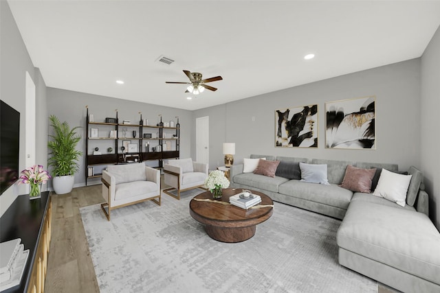 living area with a ceiling fan, recessed lighting, visible vents, and wood finished floors