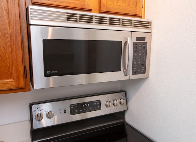 interior details featuring appliances with stainless steel finishes, mail area, and brown cabinets