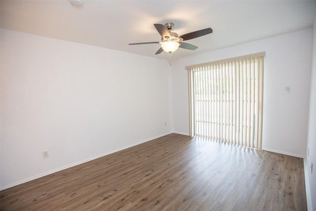 spare room featuring ceiling fan, baseboards, and wood finished floors