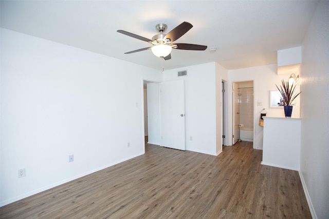 unfurnished bedroom with a ceiling fan, visible vents, baseboards, and wood finished floors