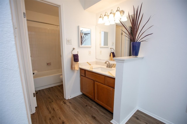 full bath featuring toilet, wood finished floors, vanity, and baseboards