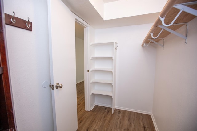 walk in closet with wood finished floors