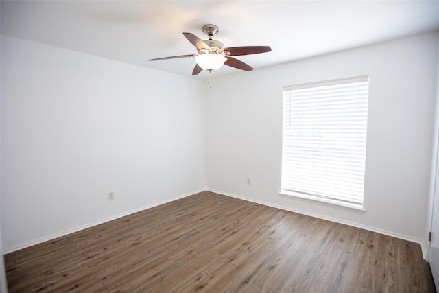 spare room with ceiling fan, wood finished floors, and baseboards