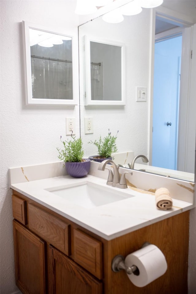 bathroom with a textured wall and vanity