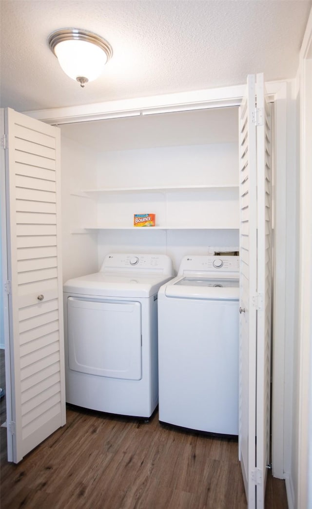 washroom with washer and dryer, laundry area, dark wood finished floors, and a textured ceiling