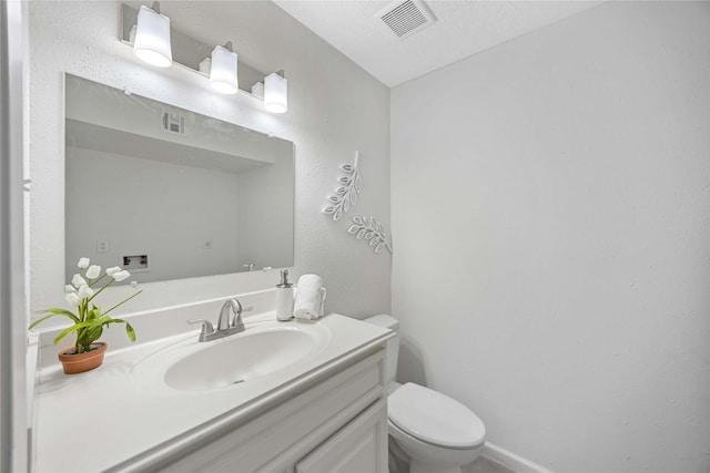 bathroom with toilet, visible vents, and vanity