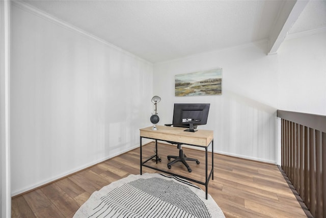 office featuring baseboards, a textured ceiling, ornamental molding, and wood finished floors