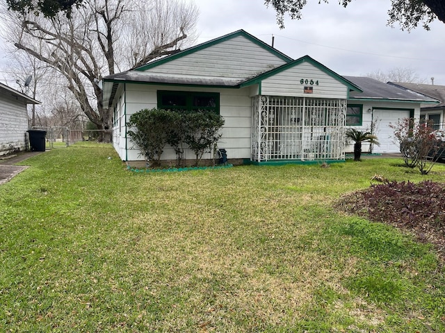 ranch-style house with a garage, fence, and a front yard