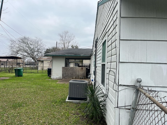 view of yard featuring central air condition unit and fence