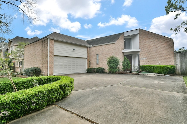 view of front facade with concrete driveway, brick siding, and an attached garage