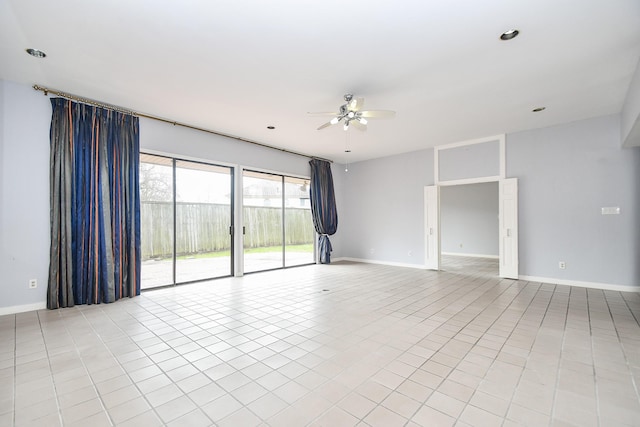 spare room featuring a ceiling fan, light tile patterned flooring, and baseboards