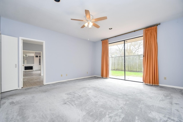 empty room featuring carpet floors, ceiling fan, and baseboards