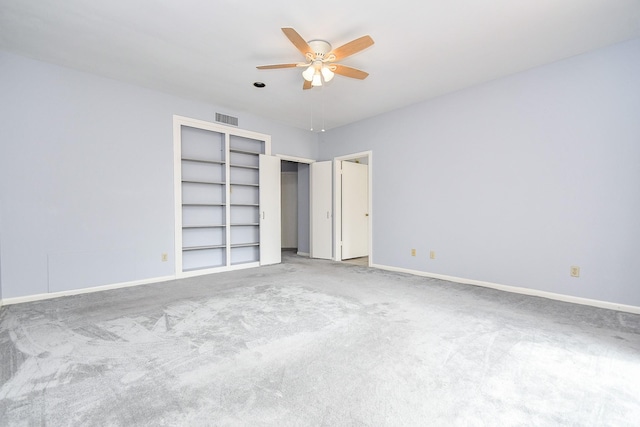 unfurnished bedroom with carpet floors, baseboards, visible vents, and ceiling fan