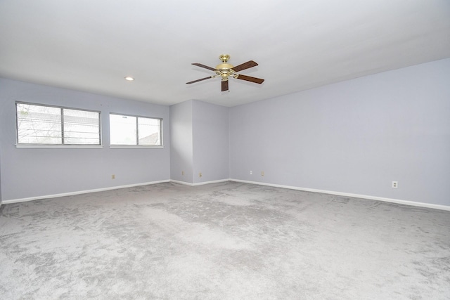 spare room featuring carpet flooring, a ceiling fan, and baseboards