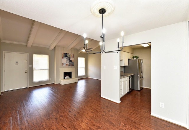 unfurnished living room with dark wood-style flooring, a fireplace, baseboards, and ceiling fan with notable chandelier