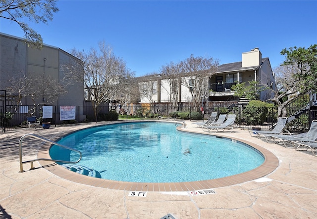 community pool featuring a patio area and fence