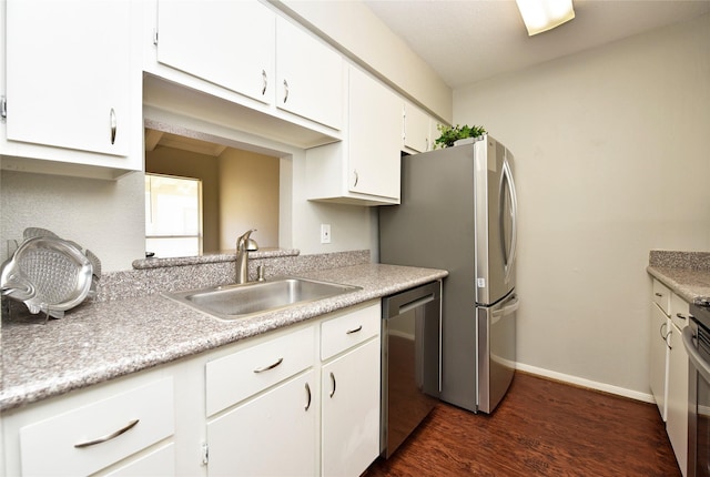 kitchen featuring stainless steel appliances, white cabinets, light countertops, and a sink