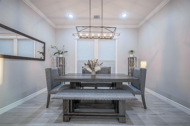 dining room featuring baseboards, visible vents, and ornamental molding