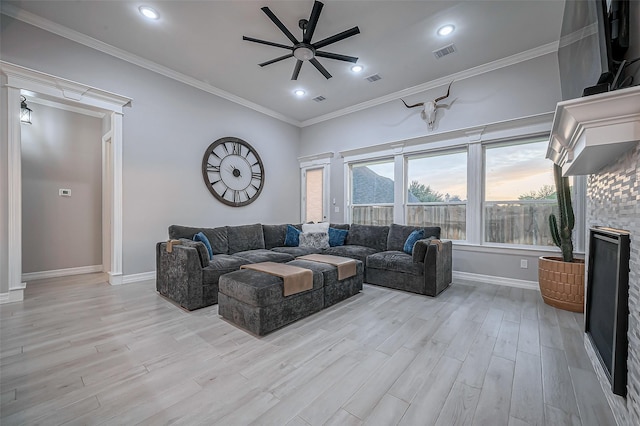 living area with baseboards, visible vents, a ceiling fan, ornamental molding, and light wood-type flooring