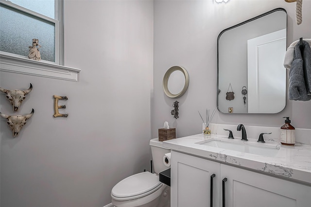 half bathroom with vanity and toilet