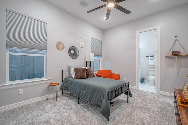 bedroom featuring baseboards, visible vents, a ceiling fan, ensuite bath, and carpet flooring