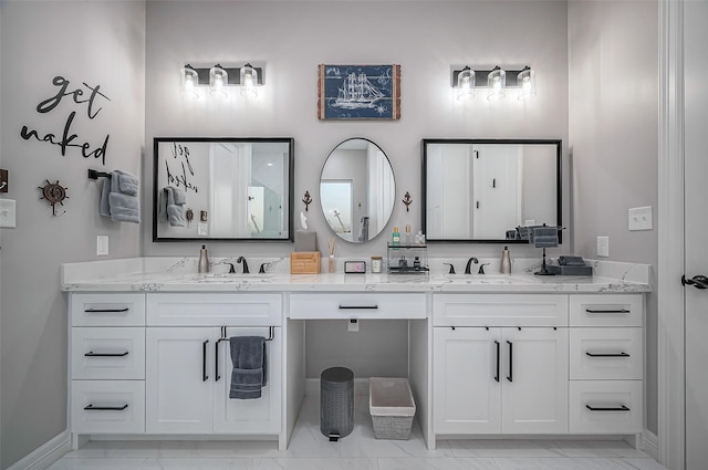 bathroom with marble finish floor, a sink, baseboards, and double vanity