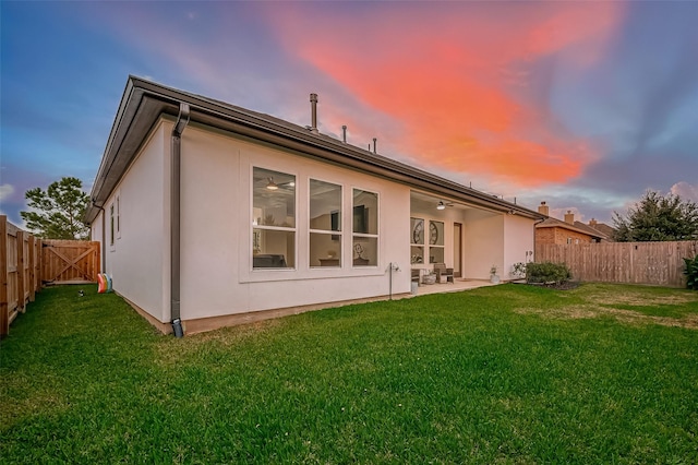 back of house featuring a patio area, a fenced backyard, and a yard