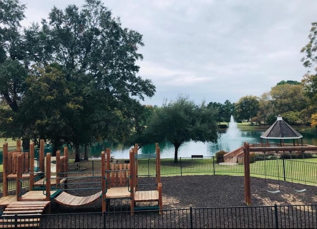 community play area with a water view and fence