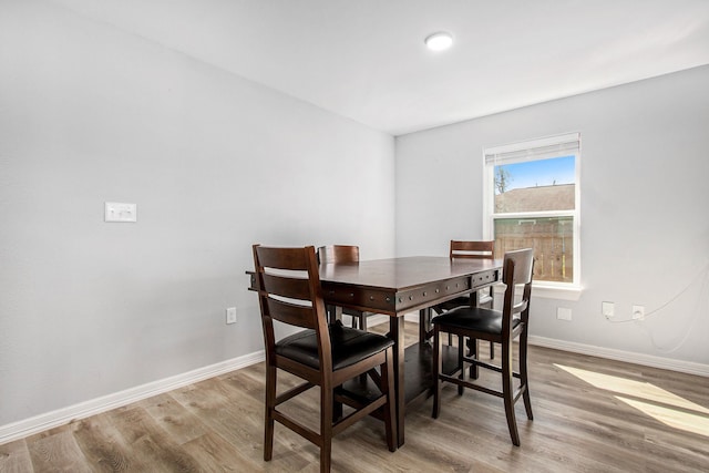 dining room featuring light wood-type flooring and baseboards