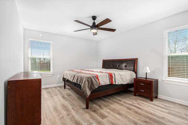 bedroom with baseboards, multiple windows, and light wood-style floors