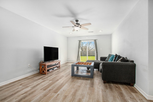 living room with ceiling fan, wood finished floors, visible vents, and baseboards