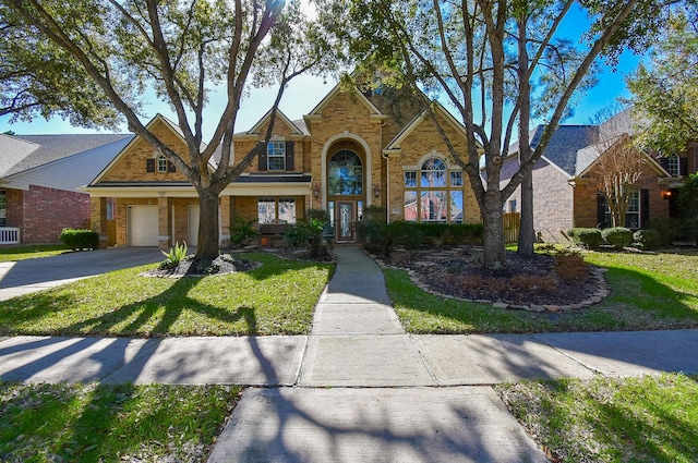 view of front of property featuring aphalt driveway, a front lawn, an attached garage, and brick siding