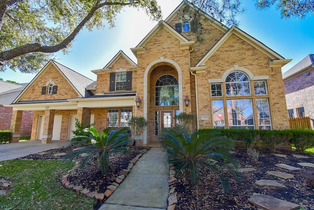 traditional-style home with a garage, driveway, and brick siding